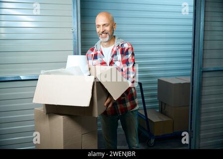 Uomo calvo che tiene una scatola con le sue cose Foto Stock