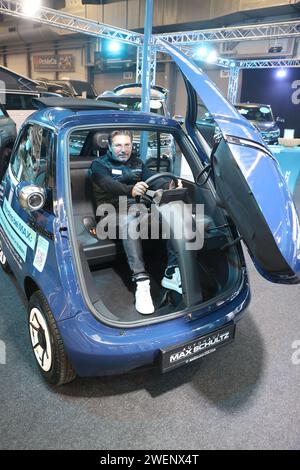 Erfurt, Germania. 26 gennaio 2024. Un dipendente siede in un'auto elettrica del marchio "Microlino" in una sala espositiva dell'Automobil Messe Erfurt. Un totale di 130 espositori mostra gli ultimi sviluppi nel mercato automobilistico in tre sale espositive. Credito: Bodo Schackow/dpa/Alamy Live News Foto Stock