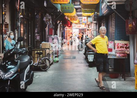 Yilan, Repubblica di Cina - 2 ottobre 2023: Una coppia di negozianti anziani e amichevoli in un colorato mercato diurno nella città di Yilan, Taiwan. Foto Stock