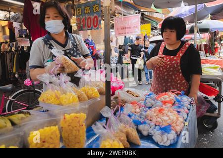 Yilan, Repubblica di Cina - 2 ottobre 2023: Venditori ambulanti e acquirenti in un vivace e colorato mercato diurno nella città di Yilan, Taiwan. Foto Stock