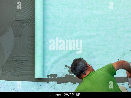 Posa di un tappetino fonoassorbente sul rasatore. Foto Stock