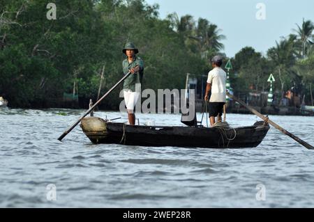 CAI RANG, VIETNAM - 17 FEBBRAIO 2013: Persone che viaggiano e lavorano con le loro barche di legno nel delta del Mekong dove il trasporto è possibile solo su b Foto Stock