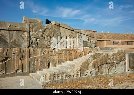 Scalinata di un palazzo in rovina adornato con intricati rilievi a Persepoli, capitale dell'Impero achemenide (550–330 a.C.), Iran. Foto Stock