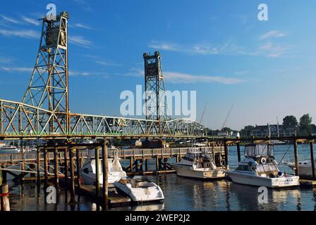 Un piccolo porticciolo si trova di fronte al Memorial Bridge, uno storico ponte verticale, a Portsmouth, New Hampshire Foto Stock