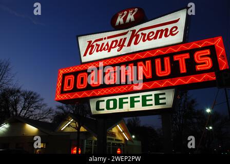 Un'insegna al neon illuminata si illumina di fronte al Krispy Krene Doughnuts, un famoso negozio di ciambelle a Raleigh, North Carolina Foto Stock