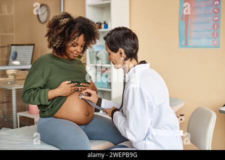 Medico che esamina una donna incinta sorridente Foto Stock