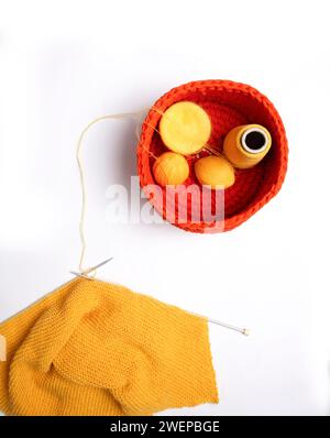 Maglione a maglia giallo su sfondo bianco. Concetto di Unione. Abiti a maglia e invernali. Vista dall'alto. Foto Stock