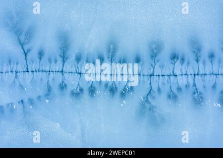 Grosse crepe nella superficie ghiacciata di un lago ghiacciato. Vista dall'alto dell'antenna. Foto Stock