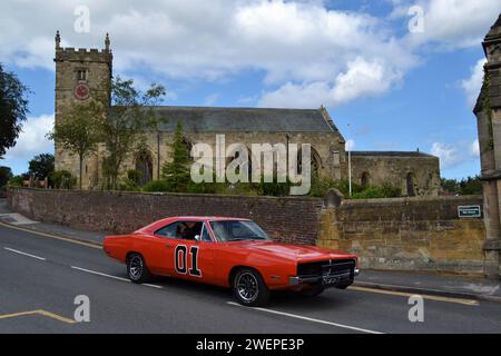 Replica 01 Dukes of Hazzard American Car passando davanti alla Chiesa di Ognissanti a Hunmanby Village North Yorkshire - Regno Unito Foto Stock