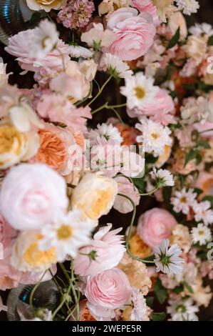 Un variopinto assortimento di fiori disposti ad arte su un tavolo in uno splendido display floreale Foto Stock