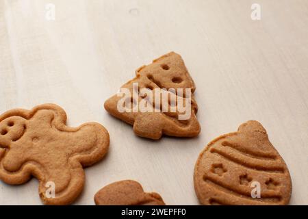 biscotti a forma di natale isolati su fondo di legno bianco Foto Stock