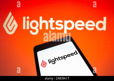 In questa immagine, il logo LightSpeed Commerce viene visualizzato sullo schermo di uno smartphone e sullo sfondo. Foto Stock
