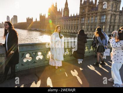 Londra, Regno Unito. 26 gennaio 2024. Una donna asiatica posa per le foto in quello che potrebbe essere un abito da sposa al sole sul Westminster Bridge. Dopo le forti piogge durante la notte, la capitale ha visto il sole e il cielo limpido fino alla sera di oggi. Crediti: Imageplotter/Alamy Live News Foto Stock