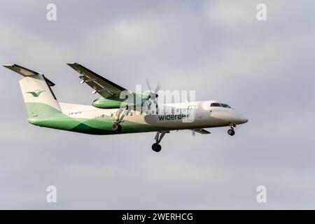 Un aereo norvegese Wideroe Airlines in volo attraverso cieli azzurri Foto Stock