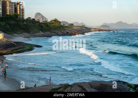 Vista parziale della spiaggia di Praia do Diabo, vista dalla roccia di Pedra do Arpoador tra i quartieri di Ipanema e Copacabana, sotto il cielo azzurro del pomeriggio estivo. Foto Stock