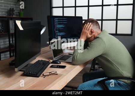 Programmatore maschio maturo e stressato che lavora in ufficio Foto Stock