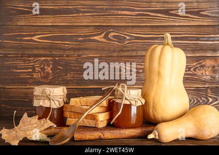 Barattoli di marmellata dolce di zucca e toast su fondo di legno Foto Stock