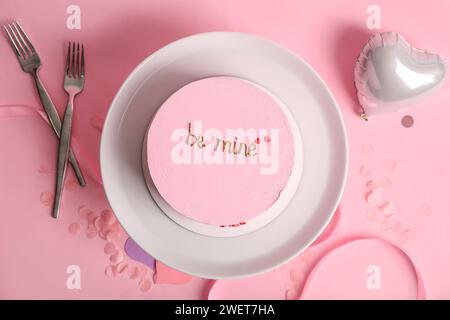 Preparati con una torta bento, forchette e un pallone aerostatico a forma di cuore su sfondo rosa. Festa di San Valentino Foto Stock