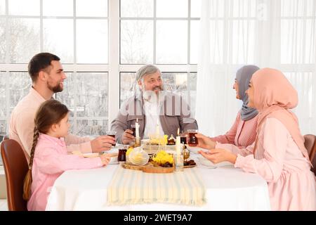 Uomo musulmano maturo che cena in famiglia a casa. Festa del Ramadan Foto Stock