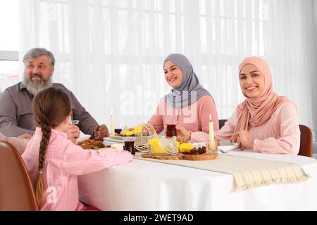 Giovane donna musulmana che cena in famiglia a casa. Festa del Ramadan Foto Stock