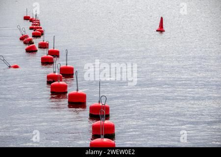 Una fila di boe rosse sull'acqua Foto Stock