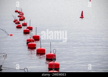 Una fila di boe rosse sull'acqua Foto Stock