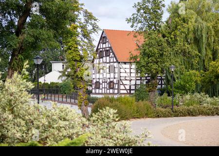 Uno splendido edificio medievale con un tetto in piastrelle rosse tra alberi verdi Foto Stock