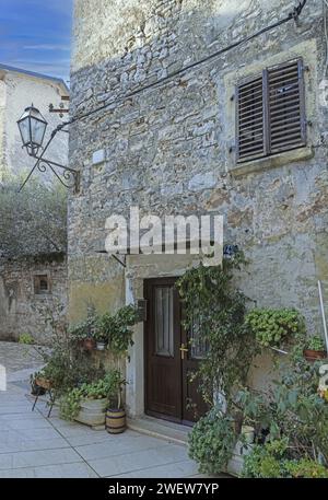 Foto di una tipica scena di strada dalla storica città croata di Voznjan con strade acciottolate e vecchi edifici alla luce del mattino Foto Stock