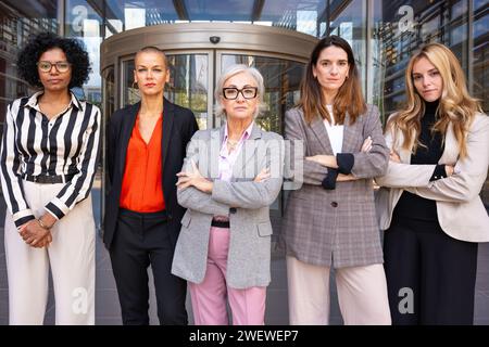 Team di donne d'affari multirazziali e diverse guidate da boss che posa seriamente per la telecamera. Foto Stock