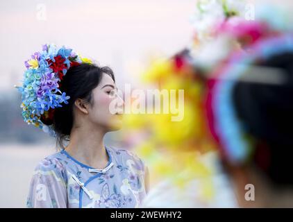 (240127) -- QUANZHOU, 27 gennaio 2024 (Xinhua) -- Un turista in un copricapo fiorito posa per le foto al villaggio Xunpu della città di Quanzhou, provincia del Fujian della Cina sudorientale, 26 gennaio 2024. I copricapo fioriti Xunpu, soprannominati "giardini sopraelevati", sono stati una firma della "Xunpu Women Customs" elencata come patrimonio immateriale nazionale nel 2008. Hanno attirato milioni di occhi nel mondo cyber all'inizio del 2023, seguito da un boom turistico sostenibile nel villaggio, dove i visitatori sono in grado di mettere letteralmente la testa in loro. Servizi fotografici, ristorazione e altri servizi di ospitalità hanno diversificato la fonte di in Foto Stock