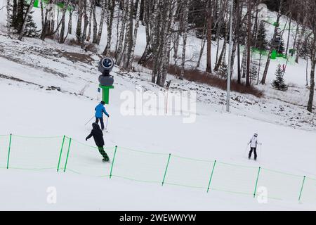 Uno sciatore scivola giù per la montagna sopra la neve bianca in una località sciistica di altai. Sport stagionali. Foto Stock
