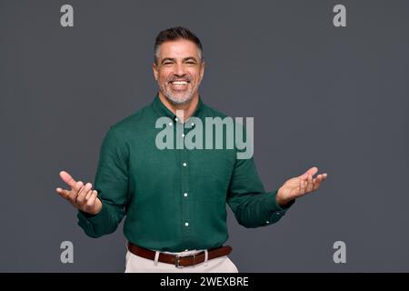 Uomo d'affari felice di mezza età che presenta annunci isolati in grigio. Foto Stock