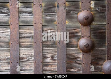 Paletto arrugginito di antica serratura su vecchia porta principale in legno del santuario. Foto Stock