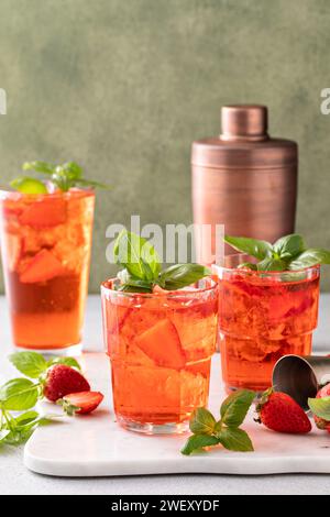 Cocktail primaverile al basilico di fragole in un bicchiere alto con fragole fresche Foto Stock