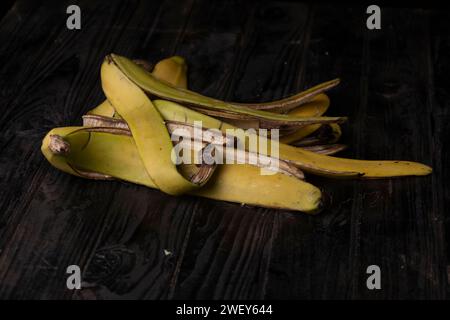 Buccia di banana su un tavolo nero Foto Stock