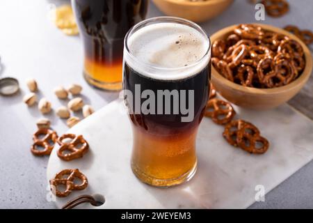 Cocktail nero e abbronzante con birra chiara e stout scura, idea tradizionale di cocktail stout Foto Stock