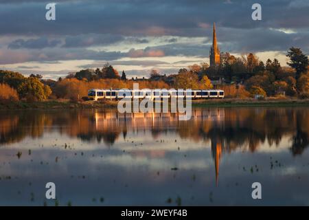 Chiltern Railways classe 165 treno Turbo riflesso nei campi allagati a Kings Sutton, Northamptonshire, Regno Unito Foto Stock