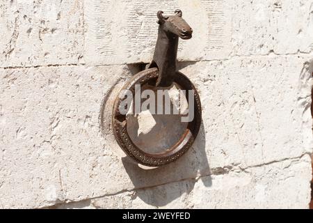 Antico anello in ferro su un muro di pietra in via europea. Foto Stock