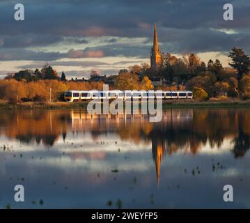 Chiltern Railways classe 165 treno Turbo riflesso nei campi allagati a Kings Sutton, Northamptonshire, Regno Unito Foto Stock