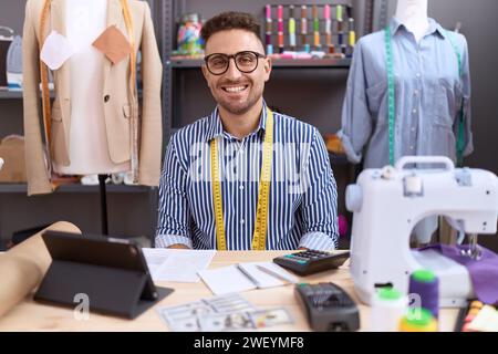 Uomo ispanico con il designer della barba che lavora in atelier con un sorriso felice e fresco sul viso. persona fortunata. Foto Stock