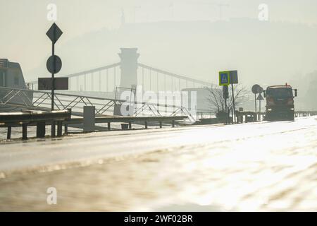 Budapest, Ungheria - 30 dicembre 2023: Veicoli commerciali che puliscono la strada dopo l'allagamento. Foto Stock