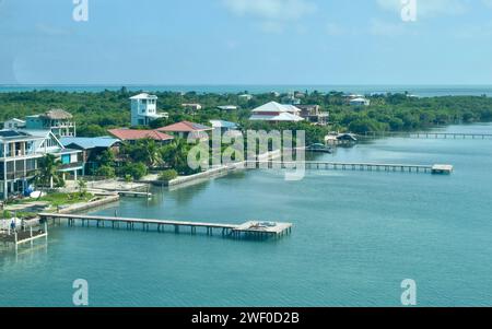 Vista aerea di Caye Caulker, Belize quando atterra da un aereo. Si possono vedere le proprietà sul fronte spiaggia così come le spiagge e i moli. Foto Stock