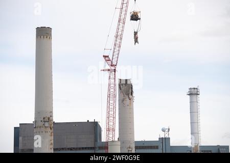 Una gru abbatte uno dei due fumogeni dell'ex centrale elettrica a carbone della Colorado Springs Utilities. Foto Stock