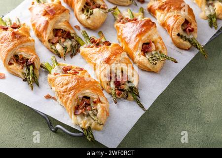 Antipasti di asparagi avvolti in pasta sfoglia con formaggio fuso e ricoperti di pancetta Foto Stock