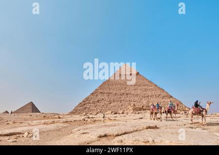 Giza, Egitto - 24 dicembre 2023: Piramide di Khafre (letto anche come Khafra, Khefren) e Menkaure con cammelli Foto Stock