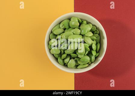 Petai o Pete Stinky Bean su ciotola in ceramica bianca, sbucciata dalla pelle. Noto come Bitter Bean, Vista dall'alto Foto Stock