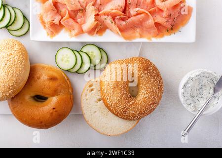 Bagel serviti con formaggio spalmabile, salmone affumicato e cetriolo fresco, bagel con losso di sesamo Foto Stock