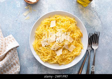 Spaghetti di zucca arrostiti e tagliati a pezzi serviti con olio d'oliva e parmigiano, idea di ricetta a basso contenuto di carboidrati, vista dall'alto Foto Stock