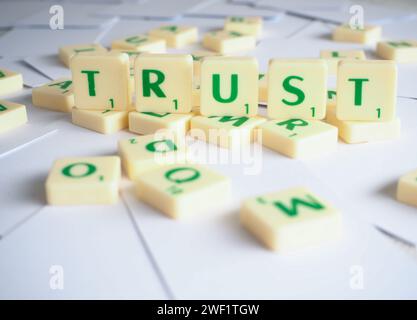 Scrabble lettere che scrivono parole Trust Foto Stock