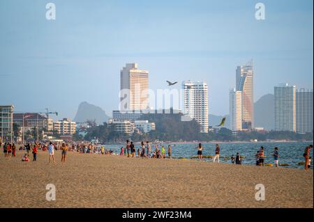 Pattaya, Thailandia, 24 gennaio 2024: Spiaggia di Jomtien in serata. la gente cammina lungo la spiaggia in attesa del tramonto. hotel a piani alti vicino al mare. Foto Stock